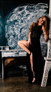 Stüdyoda dantel elbiseyle poz veren genç ve güzel bayan.  