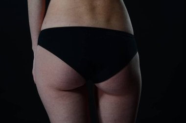 Sarı ceketli, şortlu ve topuklu ayakkabılı zarif bir kadın. Moda stüdyosu çekimi.