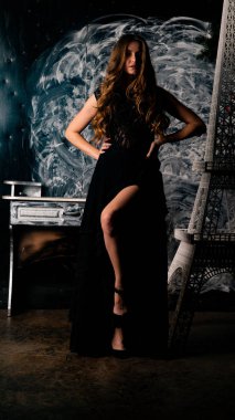 Stüdyoda poz veren narin siyah elbiseli kadın.  