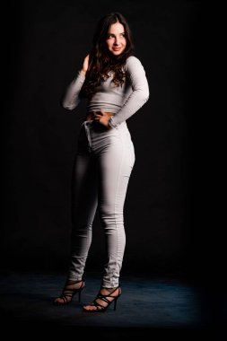 Saçları topuz şeklinde olan genç bayan kollarını kavuşturup yukarı bakıyor. Gri elbiseli, ısıran dudakları olan, arzularını düşünen kaprisli kadın manken. Hayal dünyası konsepti