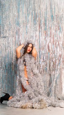 Stüdyoda poz veren parlak noel süsleriyle güzel seksi kadın, tatil konsepti.   