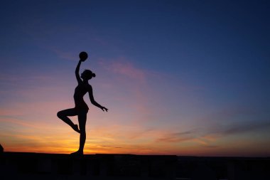 dans dansçı gün batımına karşı havada böler yok.