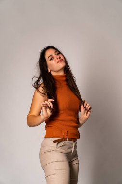 Güzel esmer model, karanlık odada poz veriyor. 
