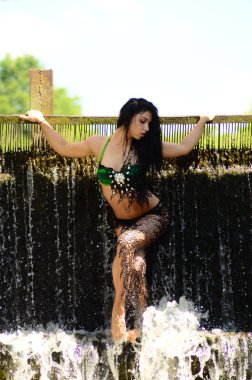 Genç esmer model bir şelale karşı poz