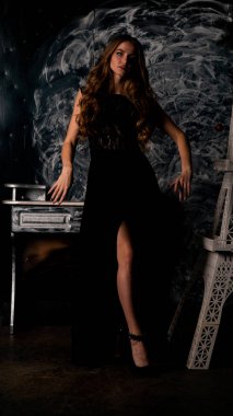 Stüdyoda poz veren narin siyah elbiseli kadın.  