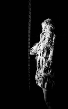 Güzel, şık, sarışın, makyajlı, siyah arka planda saç kesimi olan bir kadın.  