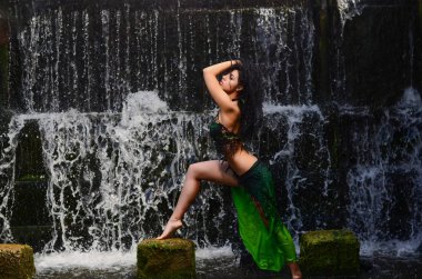 Genç esmer model bir şelale karşı poz