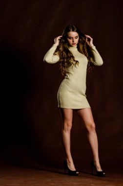 Parlak elbiseli çekici kadın siyah arka planda poz veriyor. 