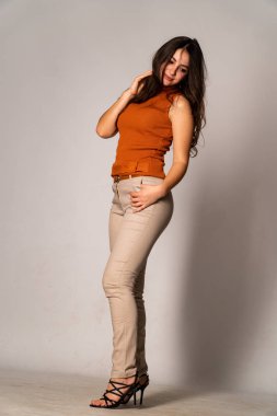 Güzel esmer model, karanlık odada poz veriyor. 