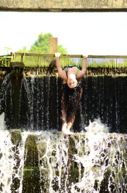 Genç esmer model bir şelale karşı poz