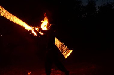 Usta fakir karanlıkta ateş gösterisi sırasında alevlerle gösteri yapıyor..