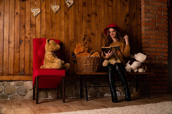 beautiful woman with book posing among toys in studio