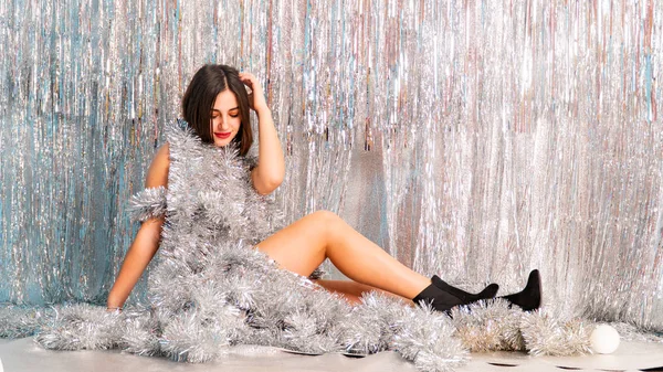 Stüdyoda poz veren parlak noel süsleriyle güzel seksi kadın, tatil konsepti.   