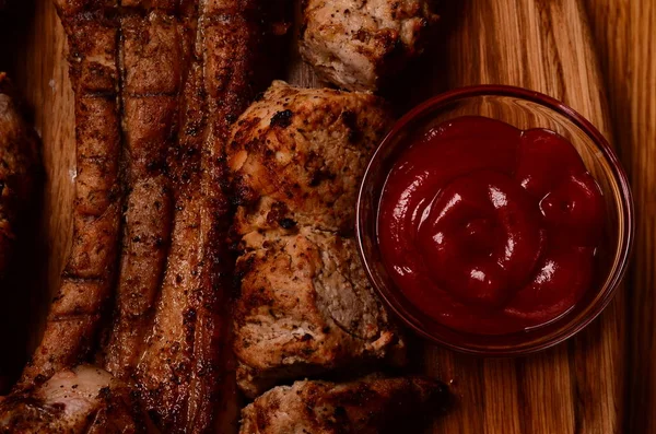 Gesneden gegrilde barbecue lendenstuk biefstuk met chimichurri saus op de snijplank op donkere houten achtergrond — Stockfoto