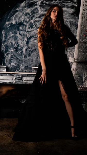 Stüdyoda poz veren narin siyah elbiseli kadın.  