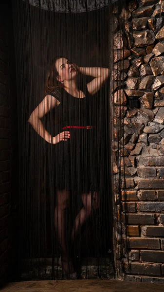 Siyah ipliklerin arkasında poz veren kadını baştan çıkar..