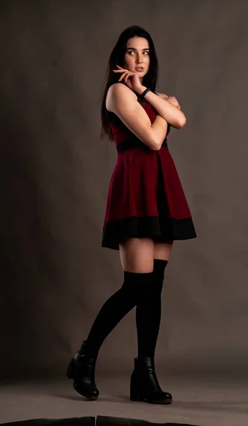 若いですブルネット女性でスタイリッシュな服でポーズでダークスタジオ — ストック写真