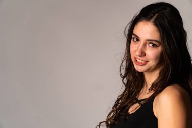 Açık renk elbiseli endişeli genç bir kadının portresi. Stüdyonun beyaz arka planında, elleri izole bir şekilde burnunu kapatıyor. İnsanlar samimi duygular, yaşam tarzı konsepti. Kopyalama alanı oluştur