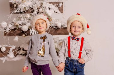 Ukraine, 28.01.2020: christmas and new year concept. happy young kids in santa claus clothes with a gift box