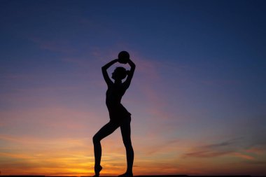 Dans eden dansçı gün batımına karşı havada yarılır.