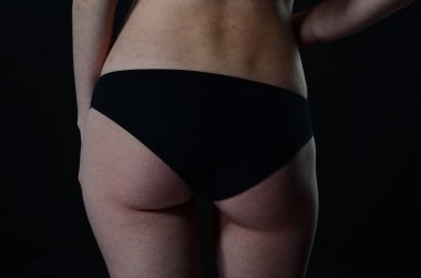 Sarı ceketli, şortlu ve topuklu ayakkabılı zarif bir kadın. Moda stüdyosu çekimi.