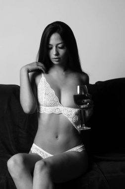 İç çamaşırlarıyla kanepede poz veren sevimli, çekici, çekici bir kızın portresi. 