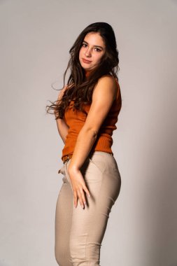 Güzel esmer model, karanlık odada poz veriyor. 