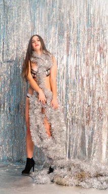 Stüdyoda poz veren parlak noel süsleriyle güzel seksi kadın, tatil konsepti.   