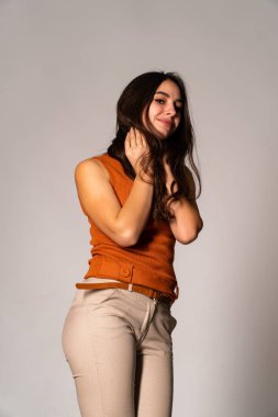 Güzel esmer model, karanlık odada poz veriyor. 