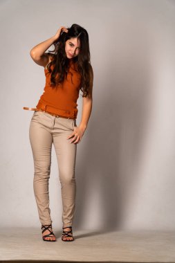 Güzel esmer model, karanlık odada poz veriyor. 