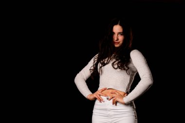 Saçları topuz şeklinde olan genç bayan kollarını kavuşturup yukarı bakıyor. Gri elbiseli, ısıran dudakları olan, arzularını düşünen kaprisli kadın manken. Hayal dünyası konsepti