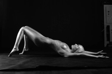 Gümüş rengi vücut boyalı genç atletik kadın.