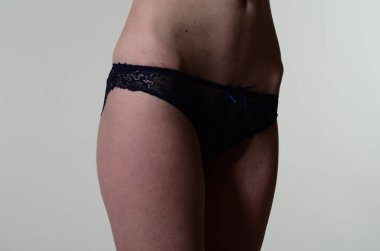 Sarı ceketli, şortlu ve topuklu ayakkabılı zarif bir kadın. Moda stüdyosu çekimi.