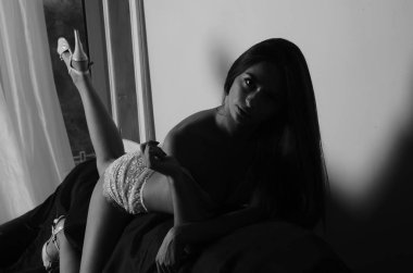 İç çamaşırlarıyla kanepede poz veren sevimli, çekici, çekici bir kızın portresi. 