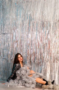 Stüdyoda poz veren parlak noel süsleriyle güzel seksi kadın, tatil konsepti.   