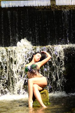 Genç esmer model bir şelale karşı poz