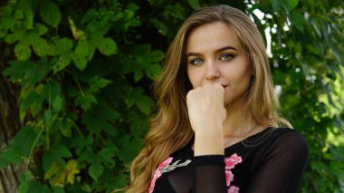 Kusursuz bir sportif beden ve onun kırmızı mayo plaj tropikal yeşil ağaçlar, arka plan ile poz göğüs ve bacak dövme düzgün sarışın kız. Kadın açık havada uzun saçlı iyi. Kavramı