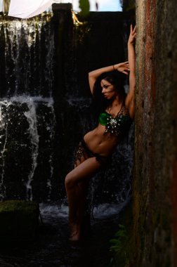 Genç esmer model bir şelale karşı poz