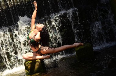 Genç esmer model bir şelale karşı poz