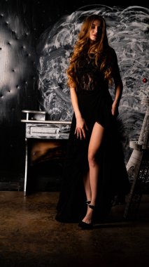 Stüdyoda poz veren narin siyah elbiseli kadın.  