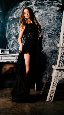 Stüdyoda dantel elbiseyle poz veren genç ve güzel bayan.  