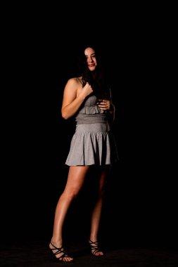 Seksi, güzel, esmer, esmer bir kadın. Kıyafet şortu ve ceket makyajı giyiyor. Ofis tarzı şık bir iş kadını. Resmi elbise. Dalgalı saçlı, çekici bir kız.