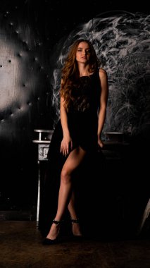 Stüdyoda poz veren narin siyah elbiseli kadın.  