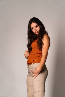 Güzel esmer model, karanlık odada poz veriyor. 