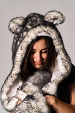 Güzel esmer manken şık kıyafetler içinde, aydınlık odada poz veriyor. 