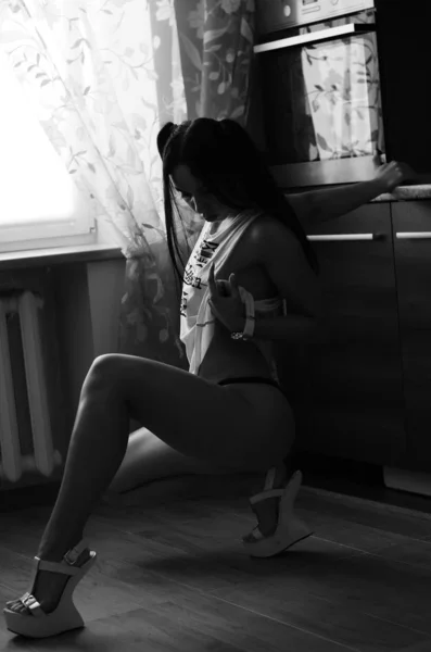 Egy gyönyörű, szexi barna nő áll az ágyneműben. — Stock Fotó