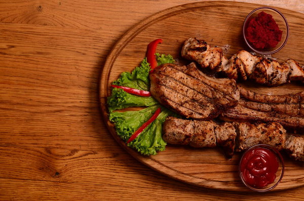 Sliced grilled beef barbecue Striploin steak with chimichurri sauce on cutting board on dark wooden background