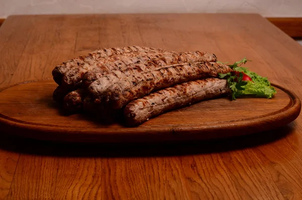 Gustose salsicce grigliate su tavola di legno — Foto Stock