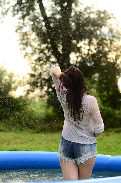 Schöne Mädchengröße plus nass im Pool, bei Sonnenuntergang — Stockfoto