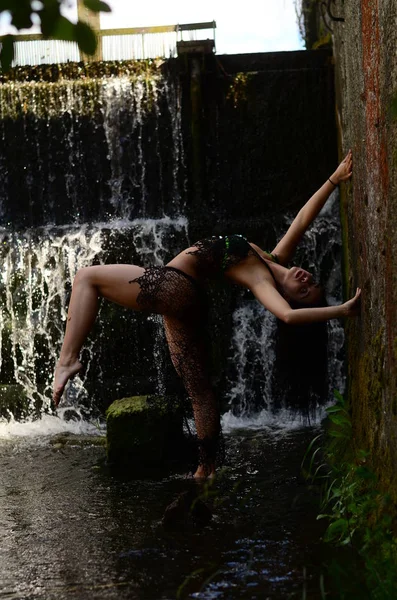 Jovem morena modelo posando contra uma cachoeira — Fotografia de Stock